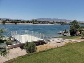 Enjoy a tranquil waterfront retreat with a spacious deck overlooking the adjacent body of water and surrounding mountains.