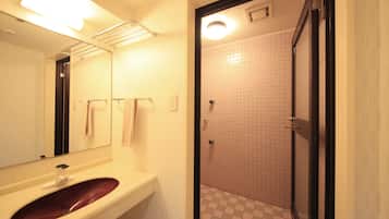 A bathroom with a white sink, a mirror, a towel rack, and a tiled shower area.