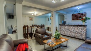 Ein geräumiger Wohnbereich mit Ledersofas, einem Couchtisch und einer Wand mit Steinverkleidung.