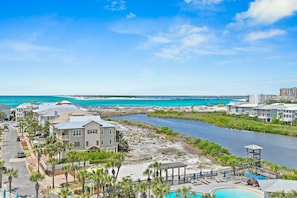 Un hôtel situé sur la côte, doté d’une piscine, offrant une vue sur la plage et traversé par une rivière.