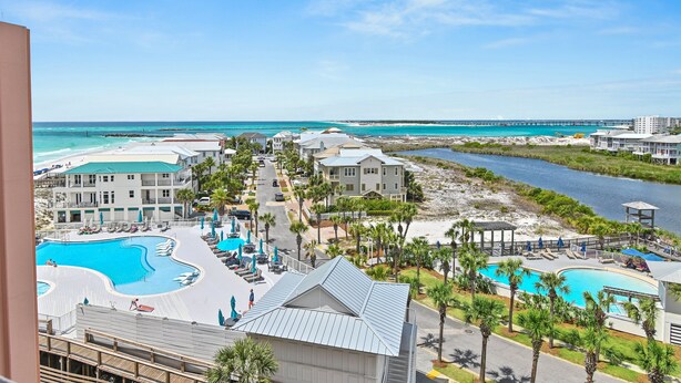 A resort with multiple swimming pools, beachfront views, and a pier extending into the water. - Sunset Jetty View! Enjoy one free beach chair set up and umbrella each day! (Destin)