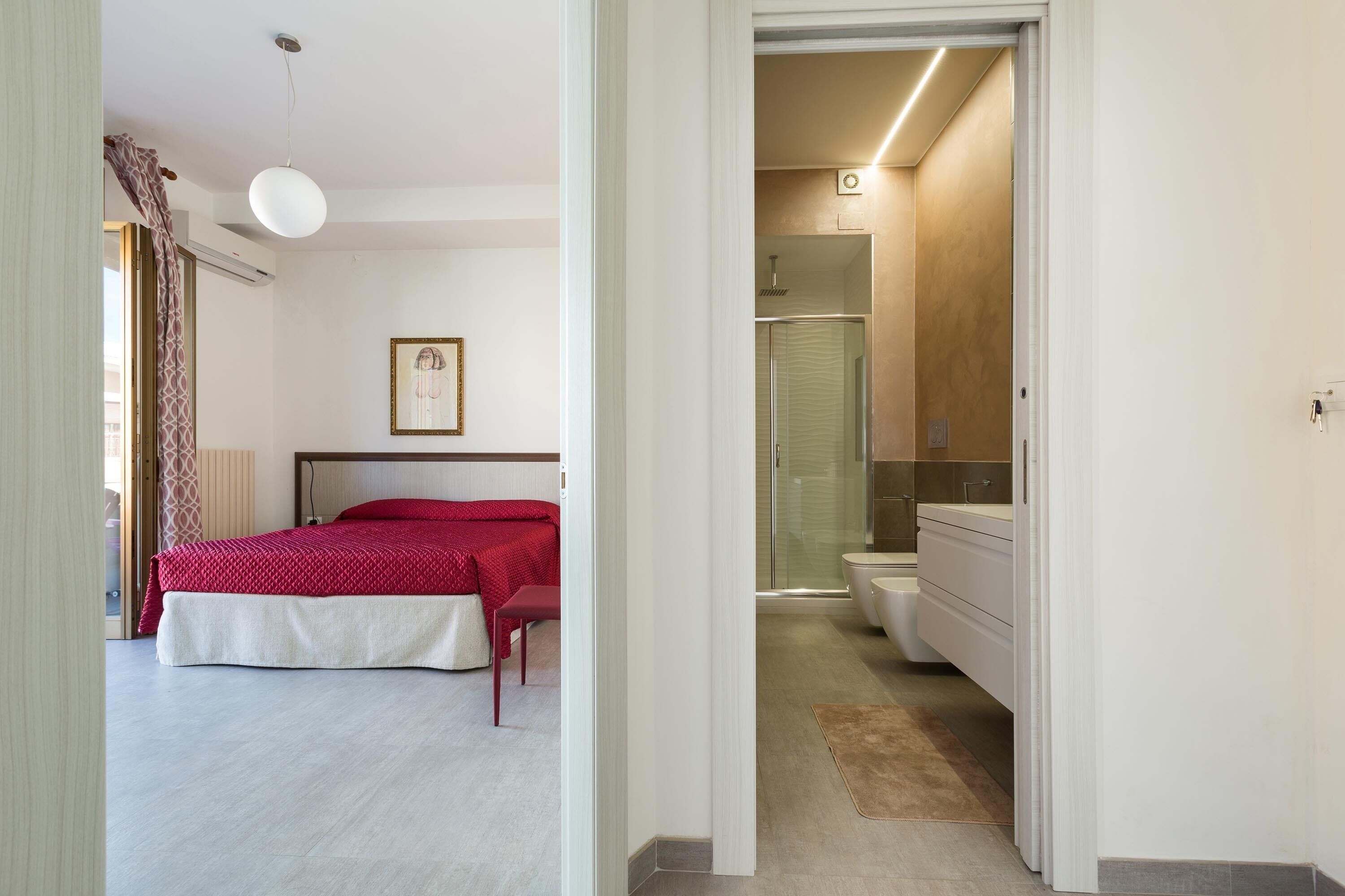 A modern bedroom with a bed, a bedside table, and a framed picture on the wall.