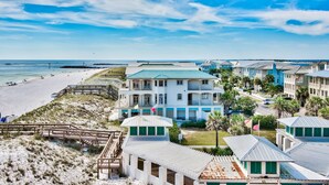 Un hotel frente a la playa con varias edificaciones, una playa y un paseo marítimo.