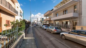 Una calle residencial con coches estacionados y edificios.