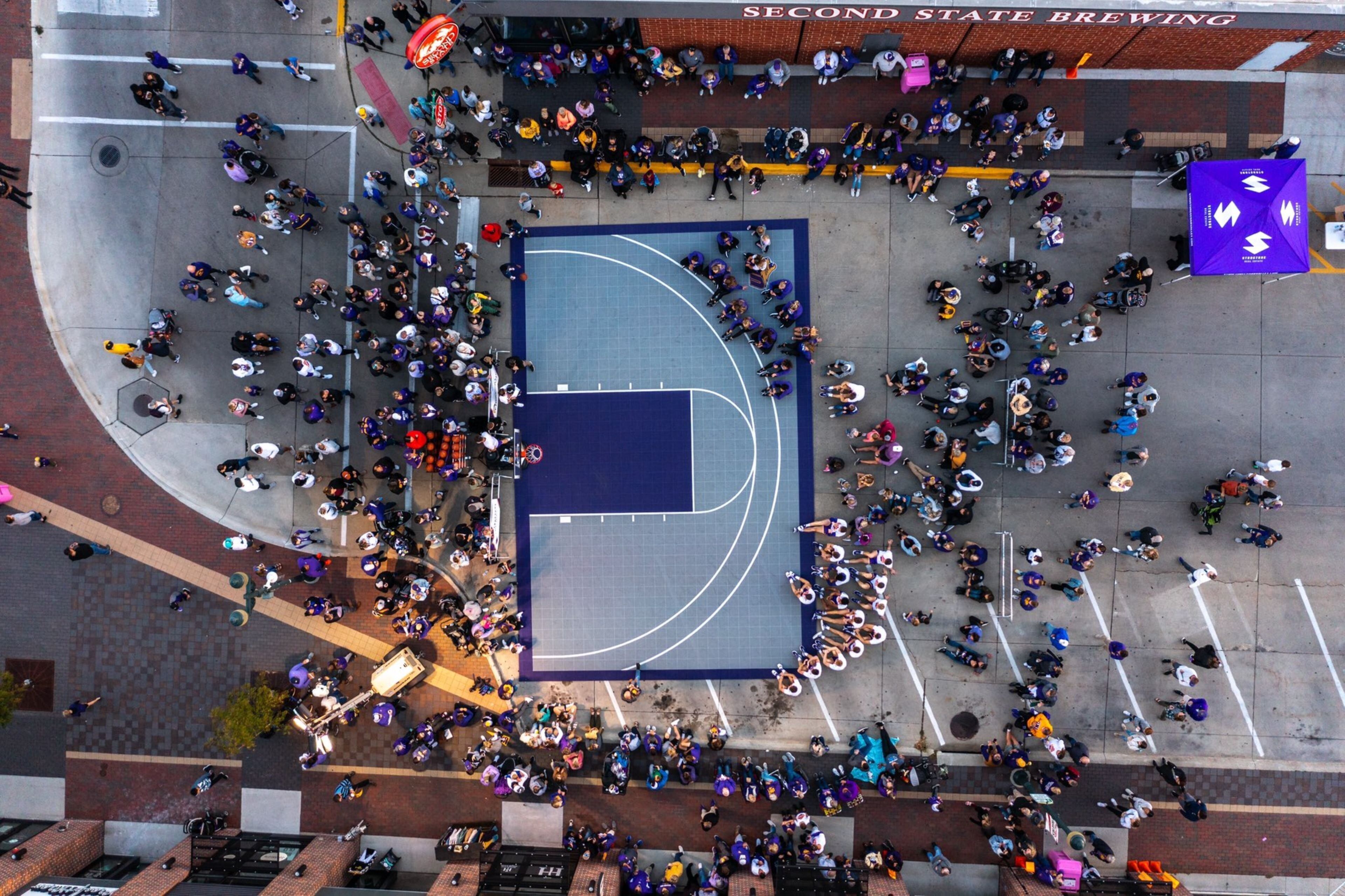 Luchtbeeld van een basketbalveld omringd door een menigte mensen.