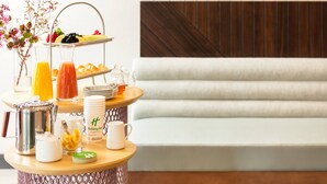 A breakfast setup with a fruit tray, juice bottles, and a coffee pot on a wooden table. - Holiday Inn & Suites Cedar Falls - Waterloo Event Ctr by IHG (Cedar Falls)