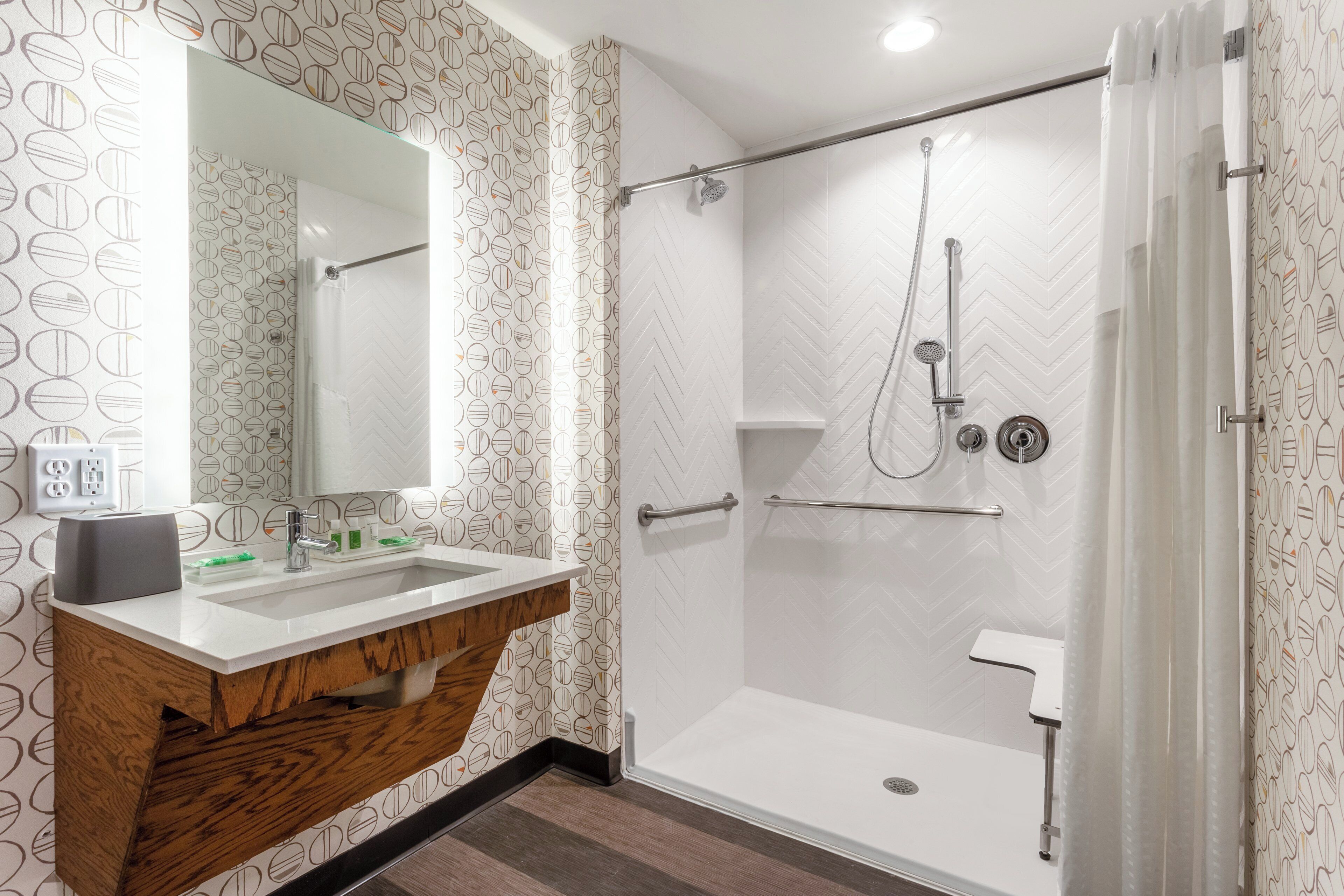 A modern bathroom with a shower, a vanity with a mirror, and a sink.