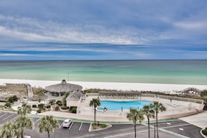 A resort with a swimming pool, beach access, and a view of the ocean.