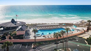 Ein Resort mit Swimmingpool, Blick auf den Strand und einem Parkplatz.