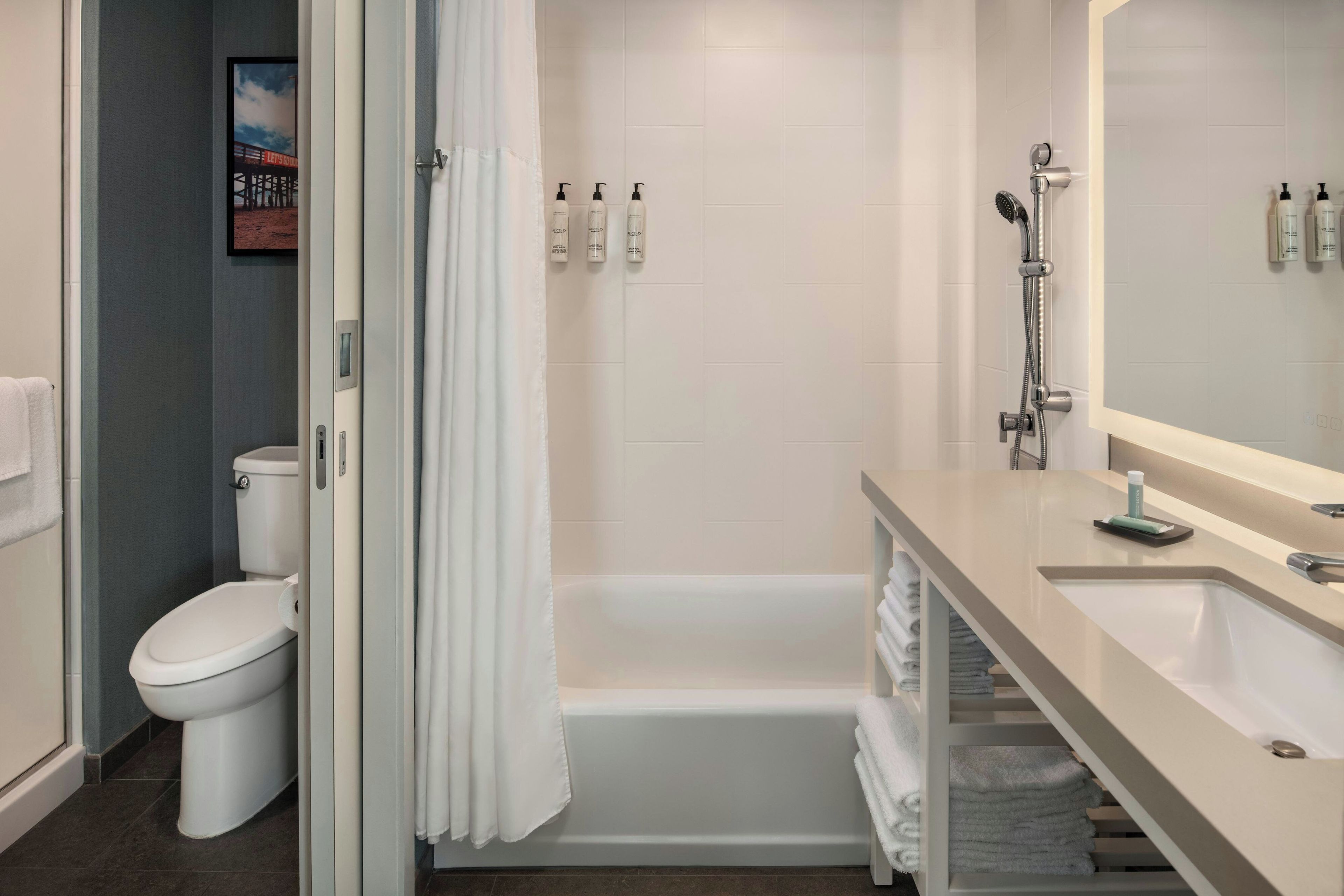 A modern bathroom with a toilet, shower, and sink.