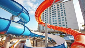 A water park with multiple slides and a hotel in the background. - Anaheim Resort Suites (Anaheim)