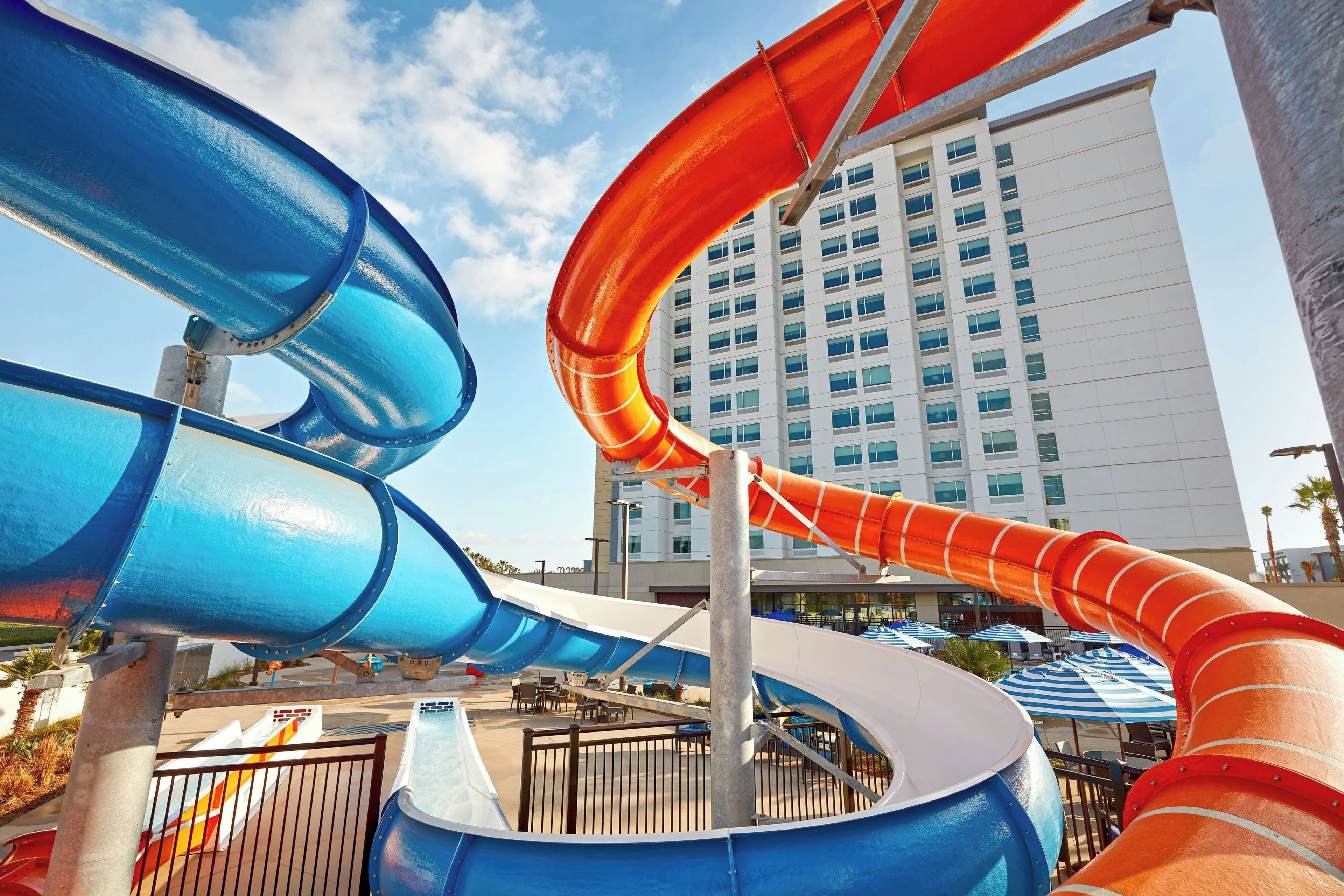 A water park with multiple slides and a large building in the background.