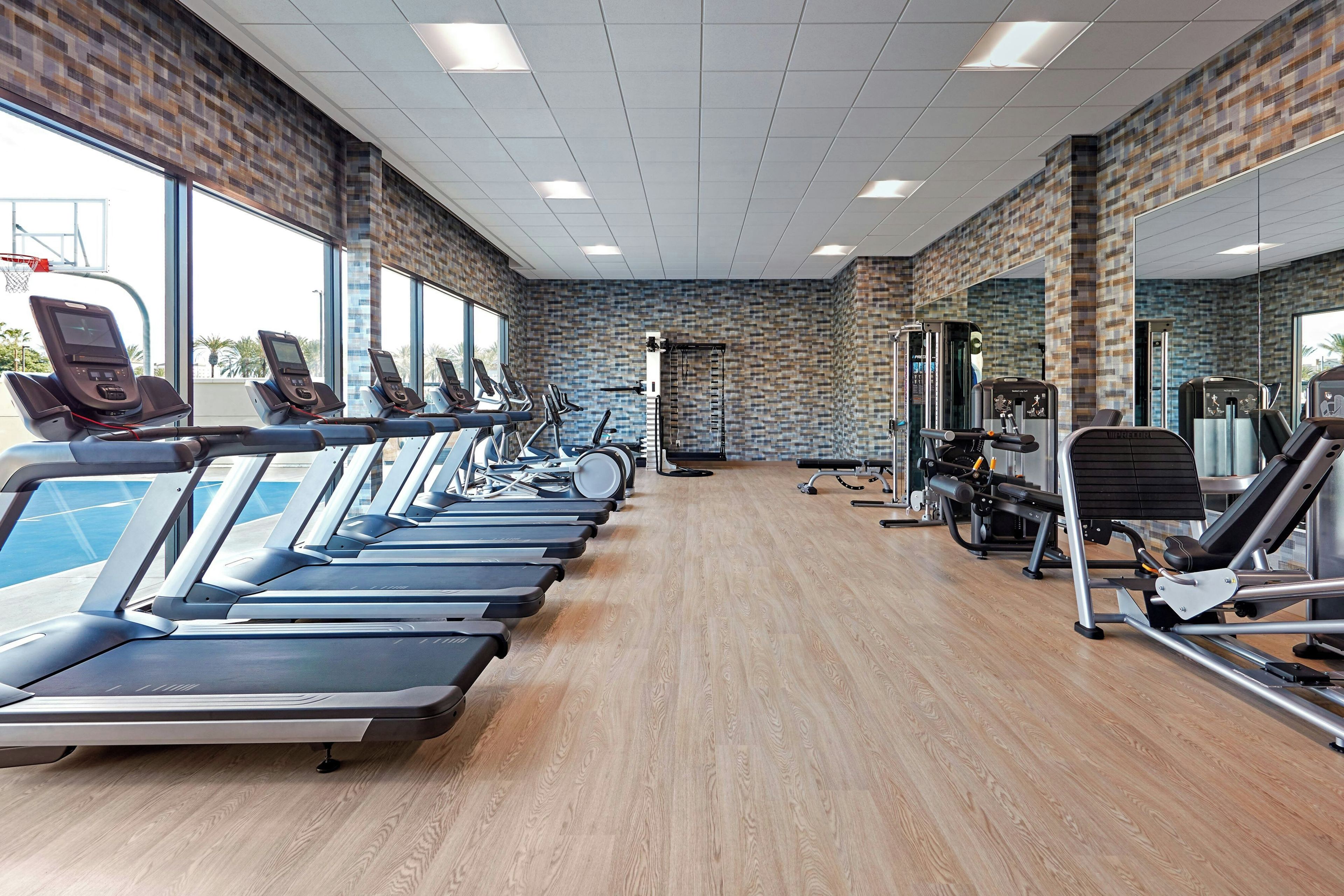 Un gimnasio con cintas de correr, bicicletas estáticas y máquinas de pesas.