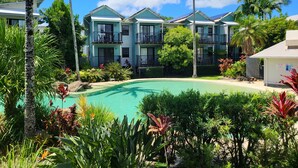 A resort with a pool, multiple-story buildings, and lush tropical landscaping. - Noosa Holiday Accommodation (Tewantin)