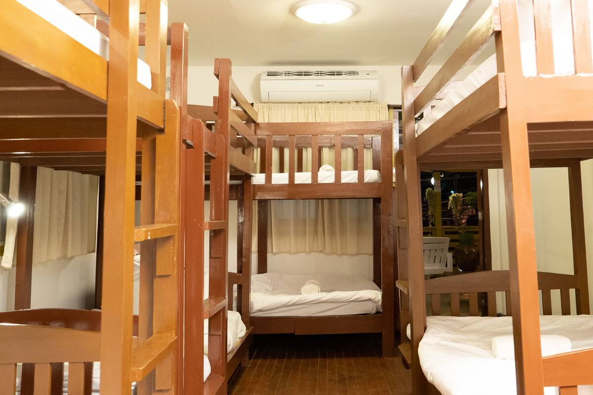 A room with bunk beds arranged in a narrow corridor.