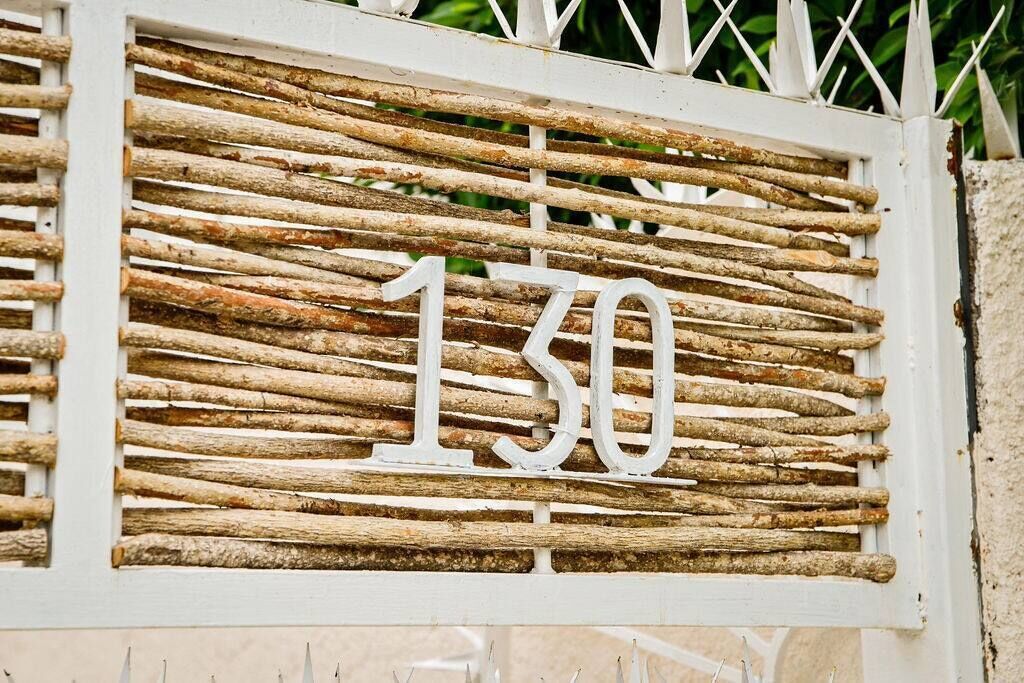 A rustic wooden number sign with the number 130.