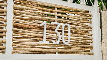 A rustic wooden number sign with the number 130.