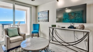 A modern living room with a large window, a ceiling fan, a TV, and a console table.
