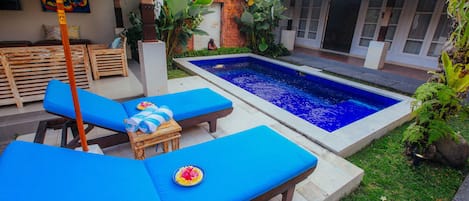 Alberca al aire libre y camastros