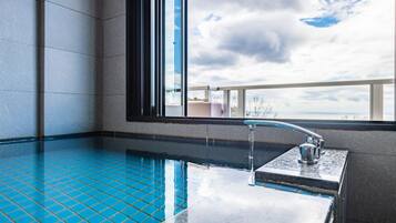 Ein moderner, überdachter Pool mit großzügigen Fenstern und Blick zum Himmel.
