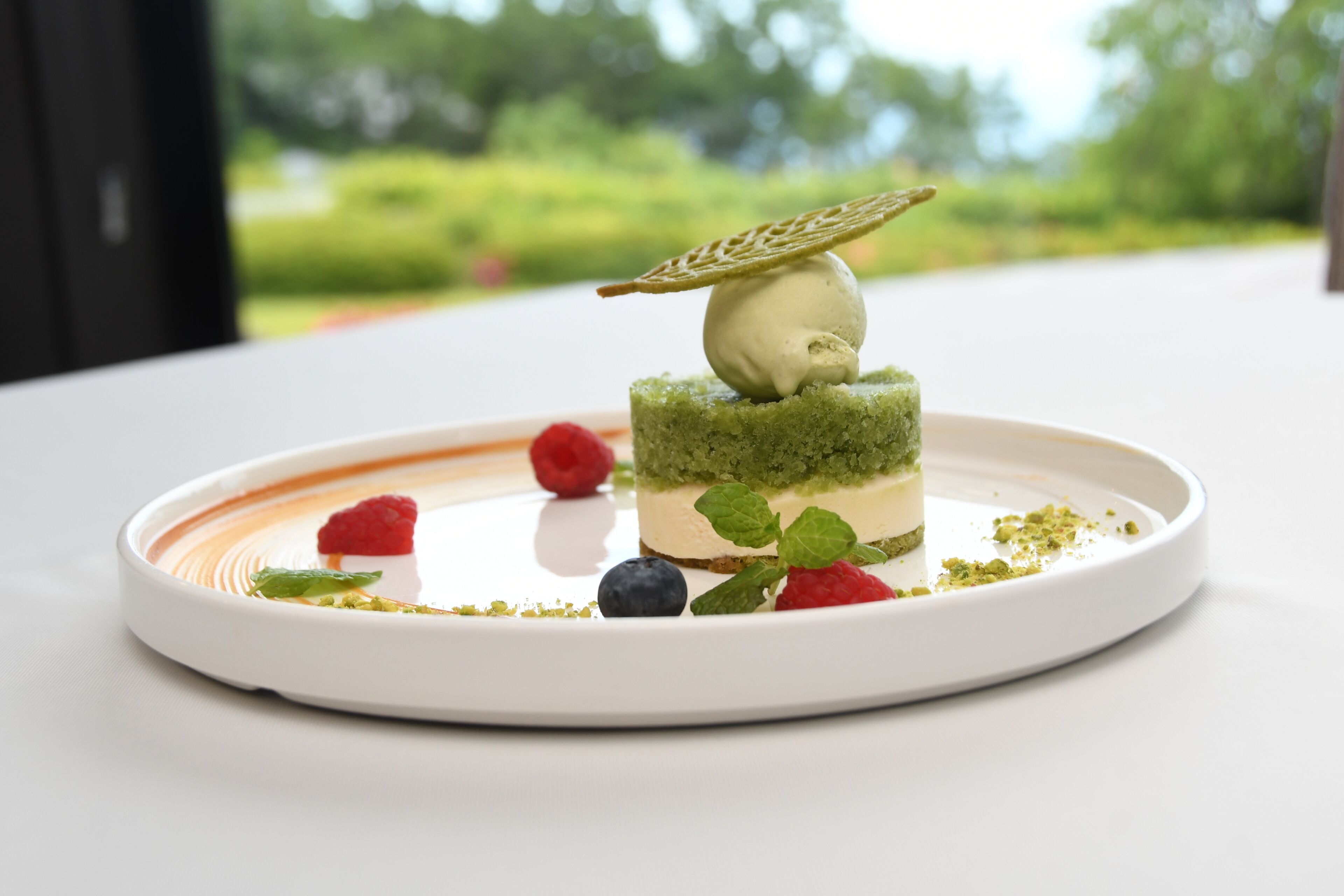 Un dessert servi dans une assiette blanche, sur un fond vert.