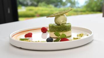 Un dessert servi dans une assiette blanche, sur un fond vert.