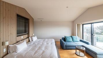 Une chambre moderne avec un grand lit, un canapé et une petite table.