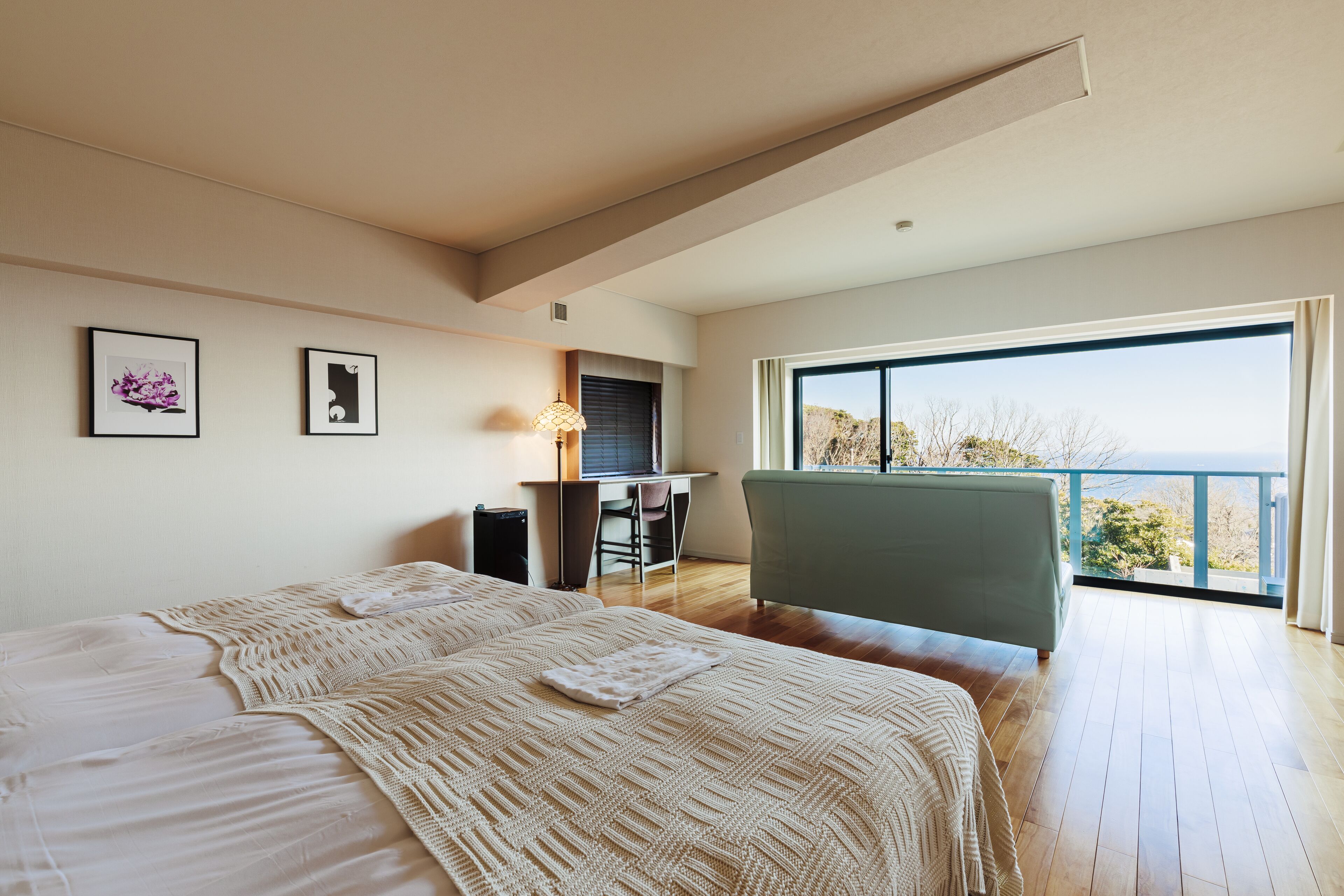 Un dormitorio moderno con una cama grande, un escritorio y vistas al exterior.