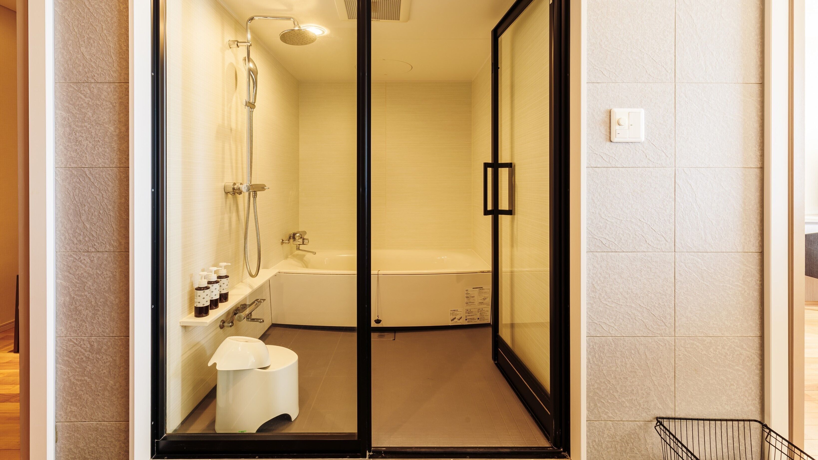 A modern bathroom with a glass-enclosed shower, a bathtub, and a toilet.