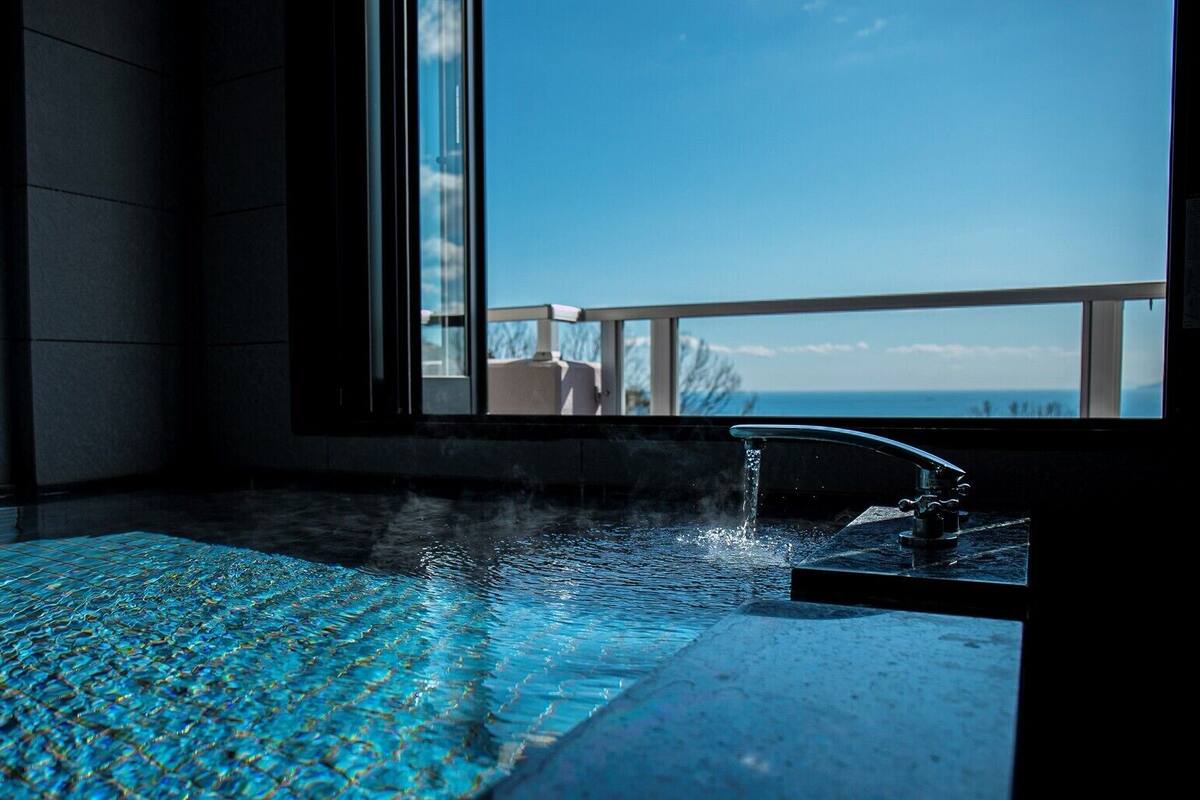 A spa area with a hot tub, a view of the sea, and a balcony.