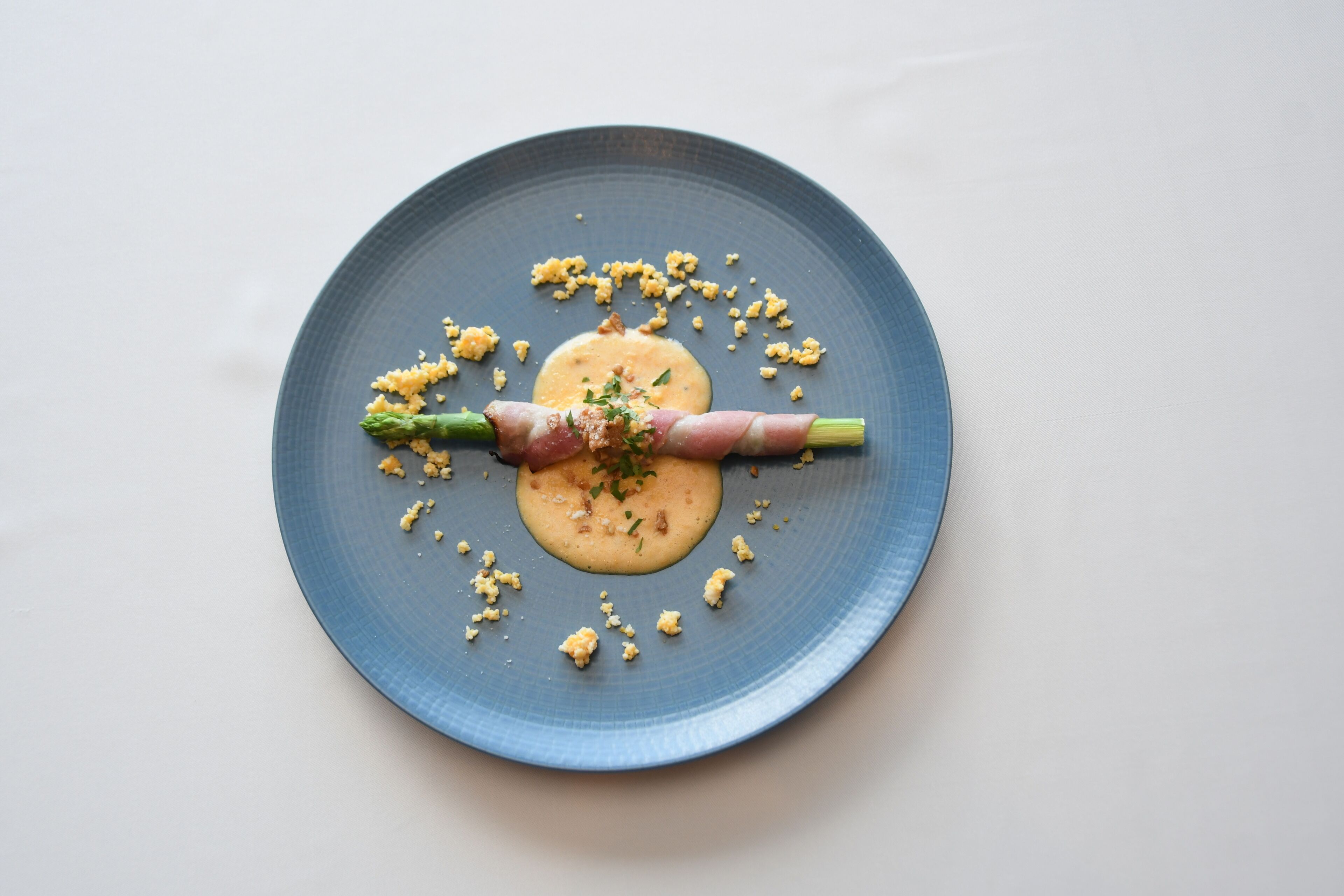 A blue plate with a central food item, surrounded by scattered food pieces.