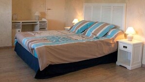 Une chambre à coucher avec un lit, des tables de chevet et une armoire.