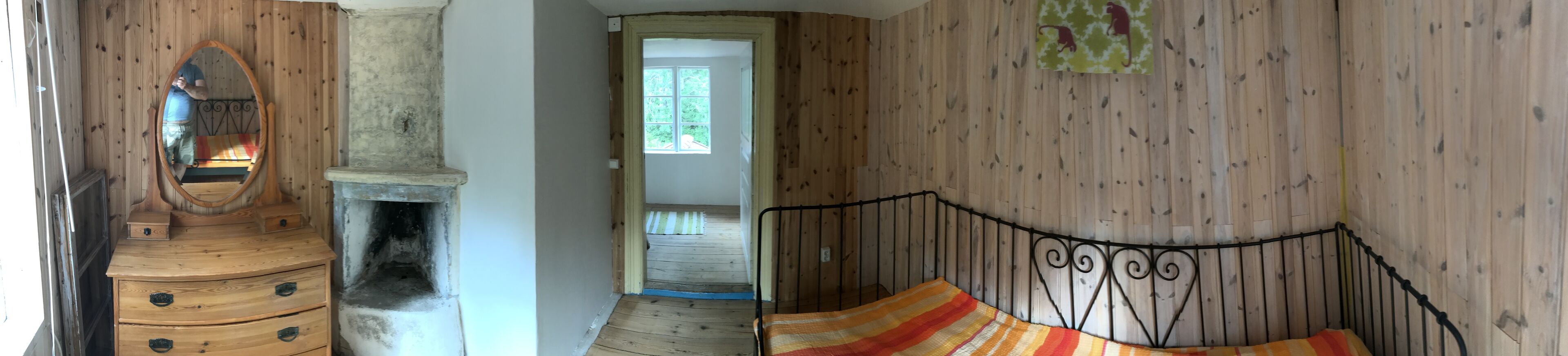 Un interior de madera con una cama, un aparador y una chimenea.