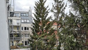 Blick auf ein Wohngebiet mit mehreren Gebäuden, darunter ein Mehrstöckiger Bau mit Balkonen und ein niedrigeres Gebäude mit rotem Dach.