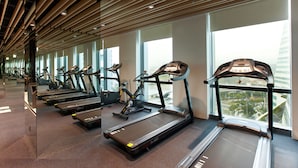 A gym with multiple treadmills and exercise bikes, large windows, and a modern ceiling design. - The Place Taipei (Taipei)