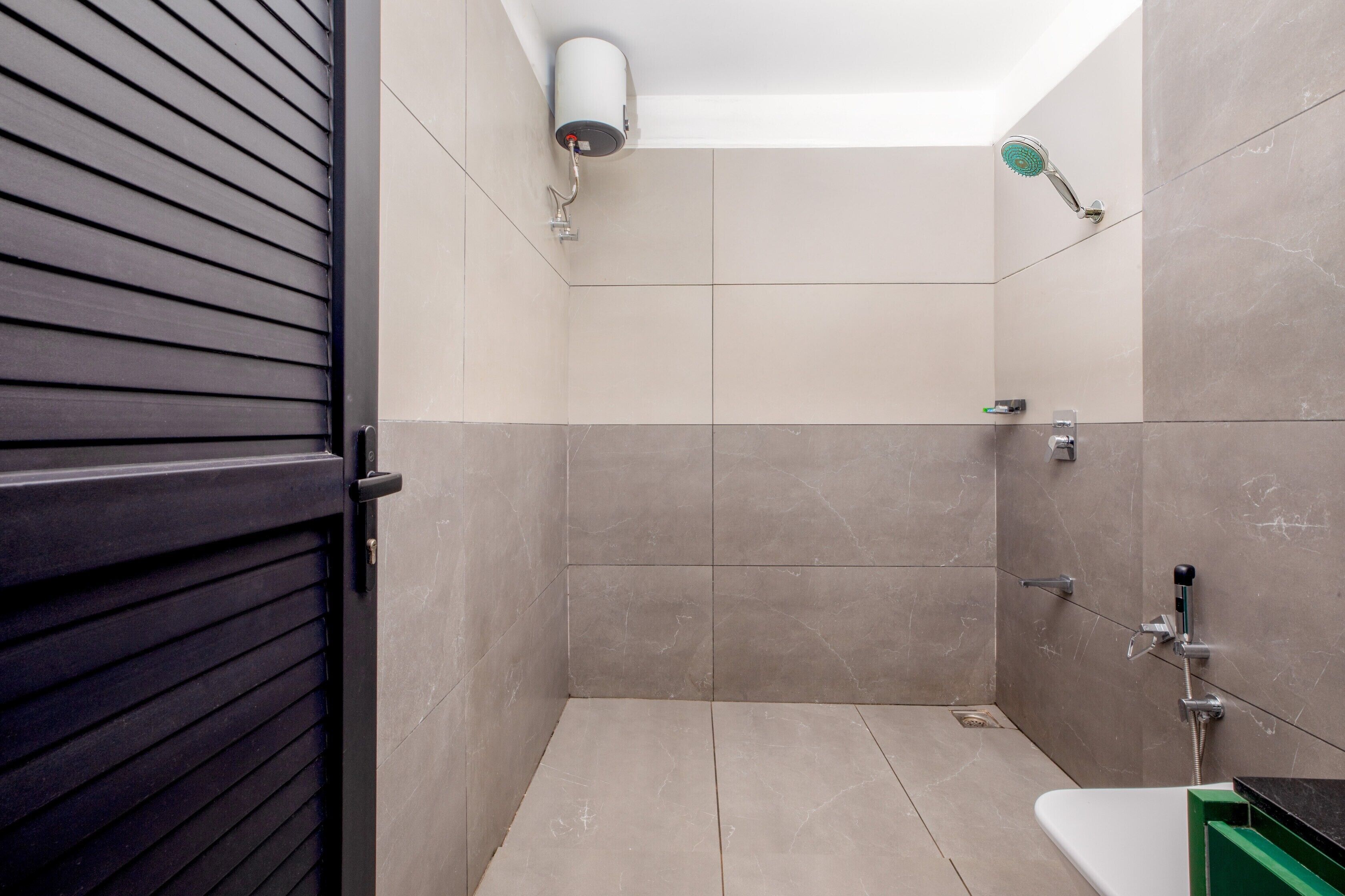 Een moderne badkamer met douche, toilet en wastafel.