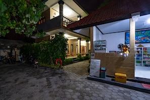 A bungalow with a tiled entrance, a reception desk, and a fan.