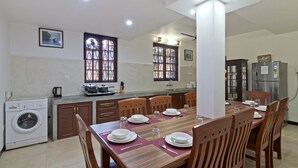 A modern kitchen with a dining area, built-in appliances, and a large window. - Beautiful 5BHK Luxury Calangute Villa, 2 Minutes Walk to Calangute Beach in Goa (Calangute)