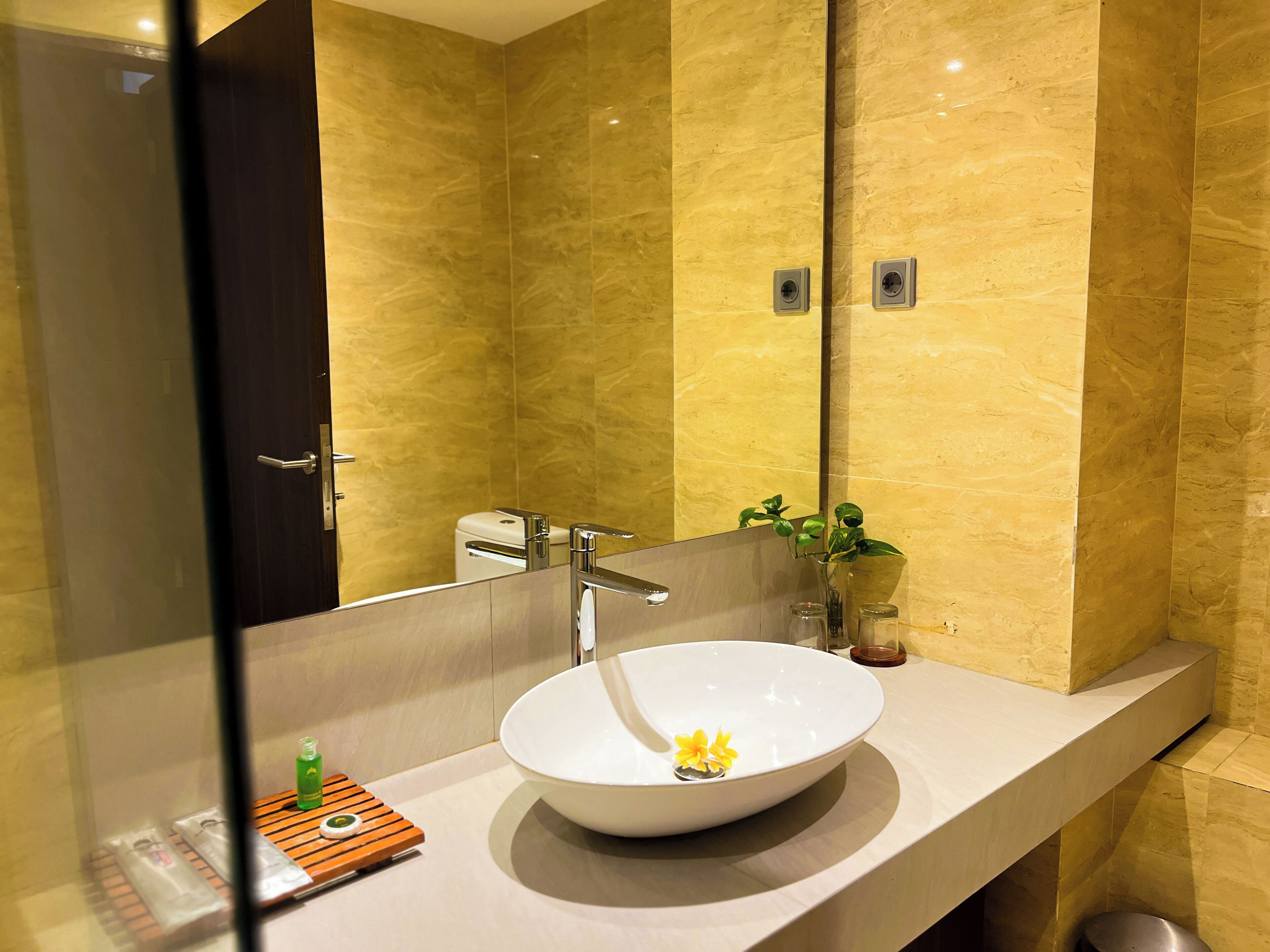 Un baño moderno con un espejo grande, un lavabo blanco y una zona de ducha.