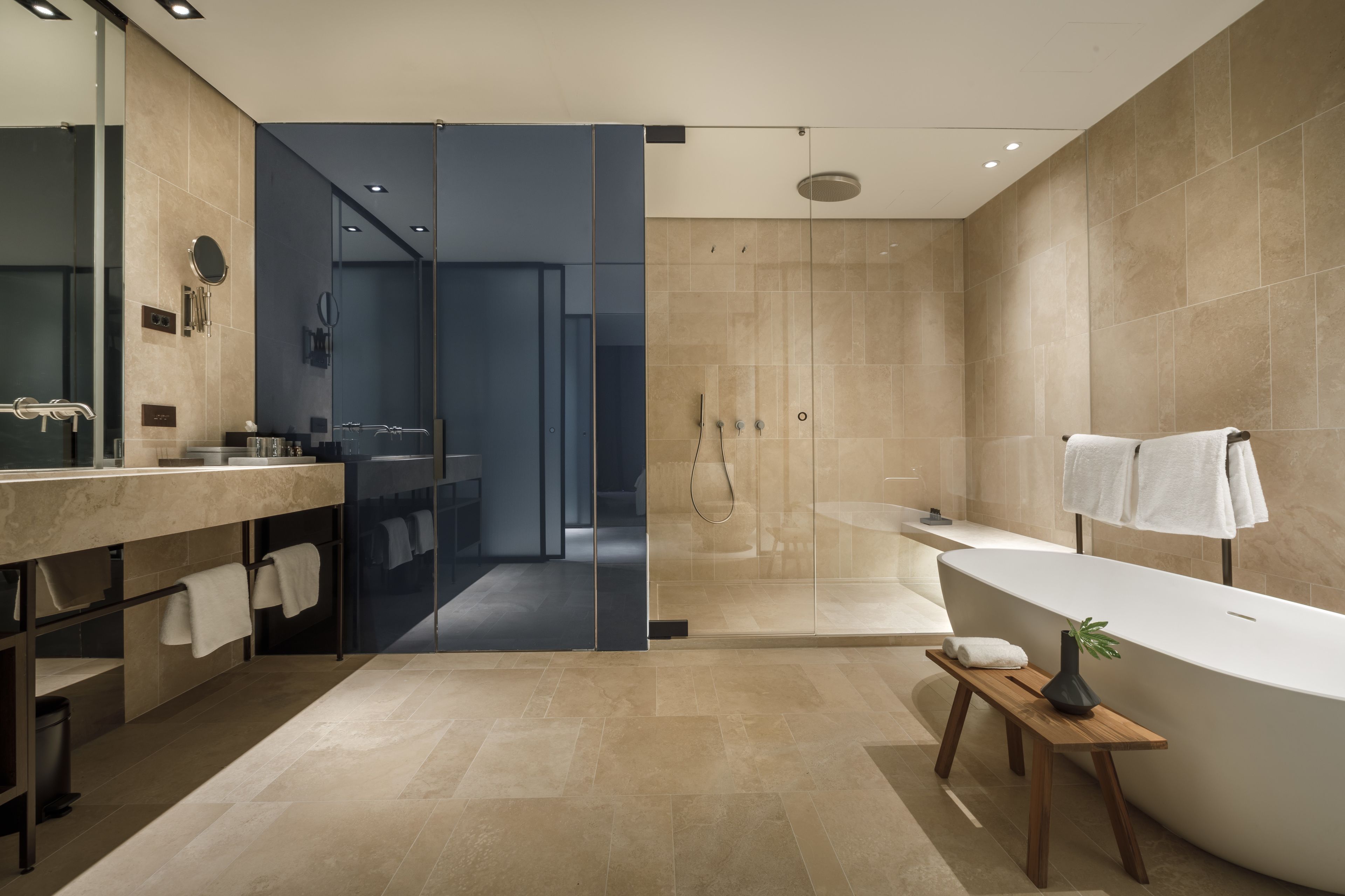 A modern bathroom with a large bathtub, a glass shower enclosure, and a vanity with a mirror.
