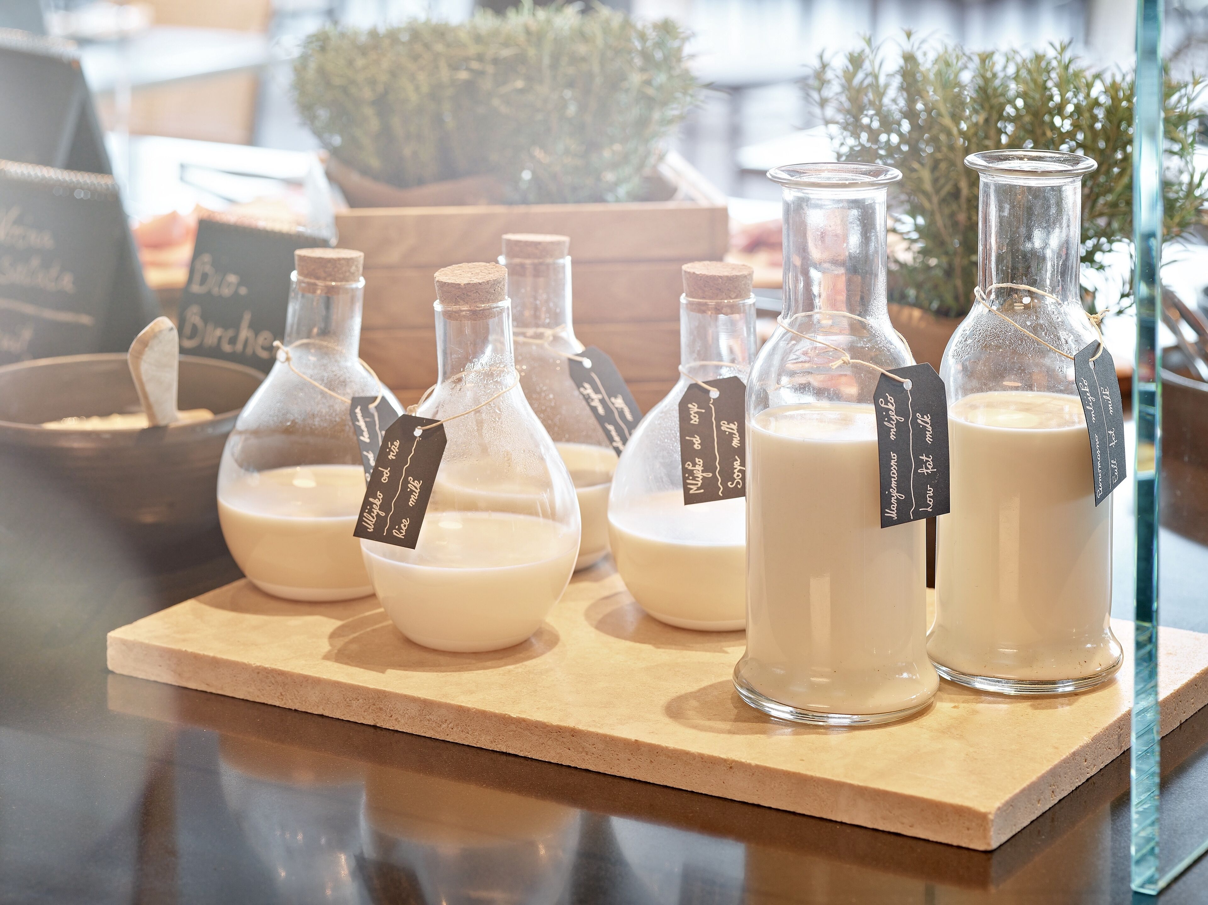 Several glass bottles with labels on a wooden board.