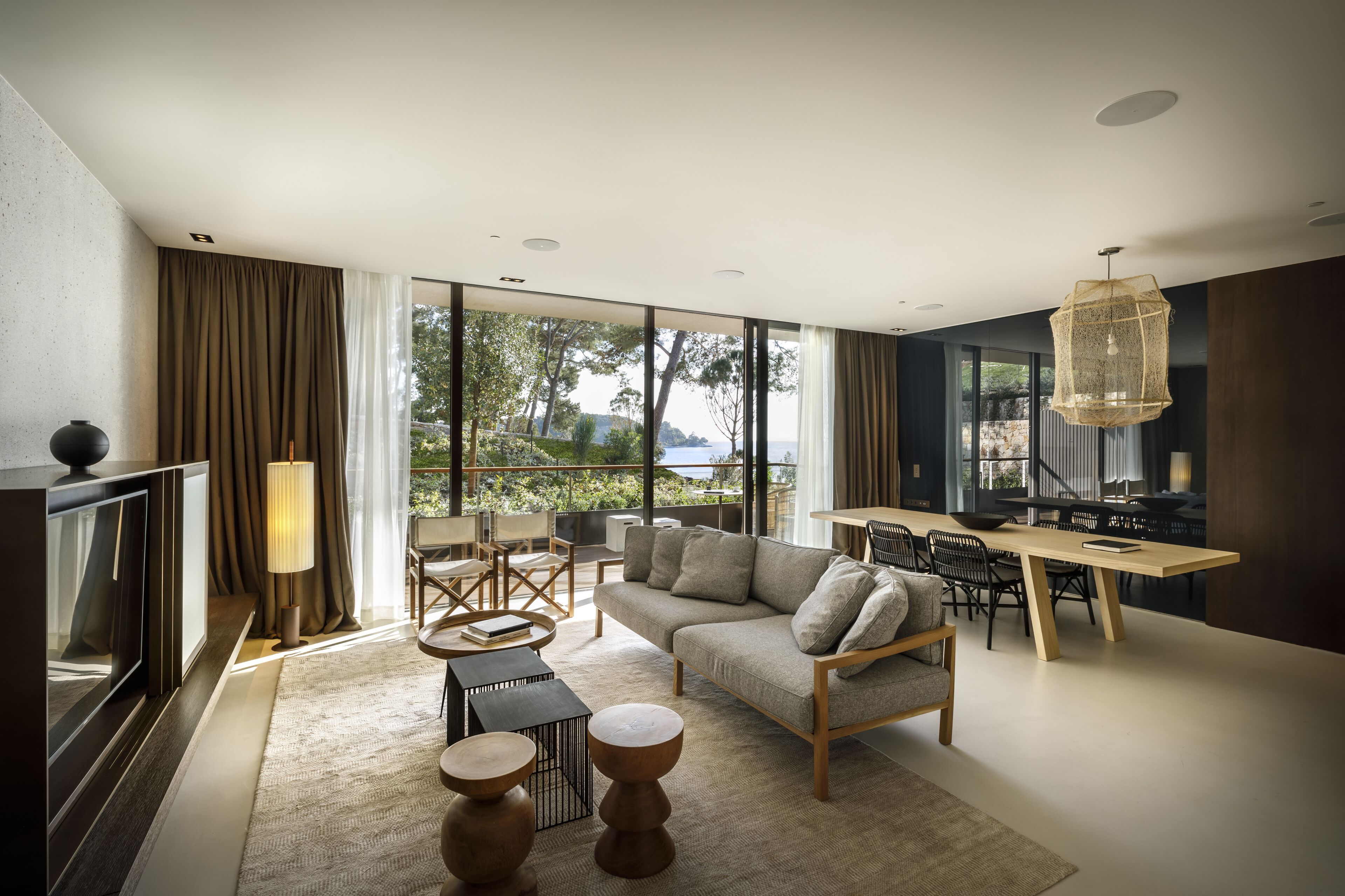 A modern living room with a sofa, coffee table, and dining area.