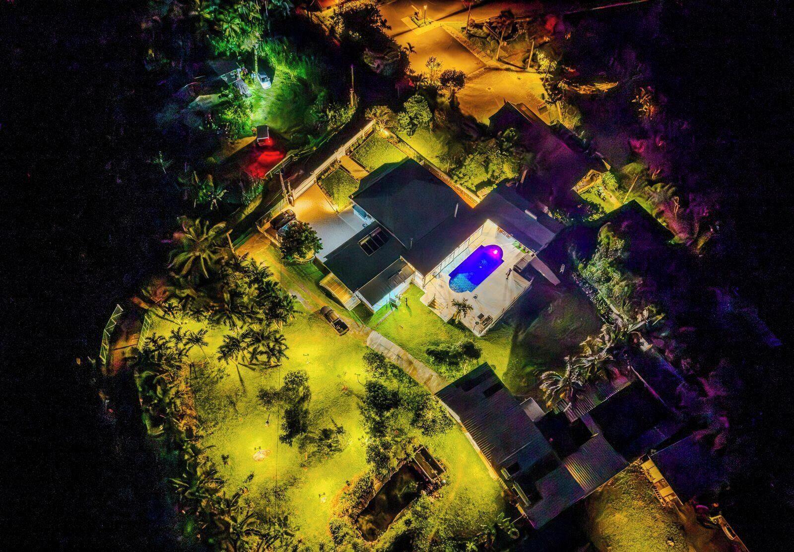 Vista aérea de una zona residencial con piscina, casas y abundante vegetación.