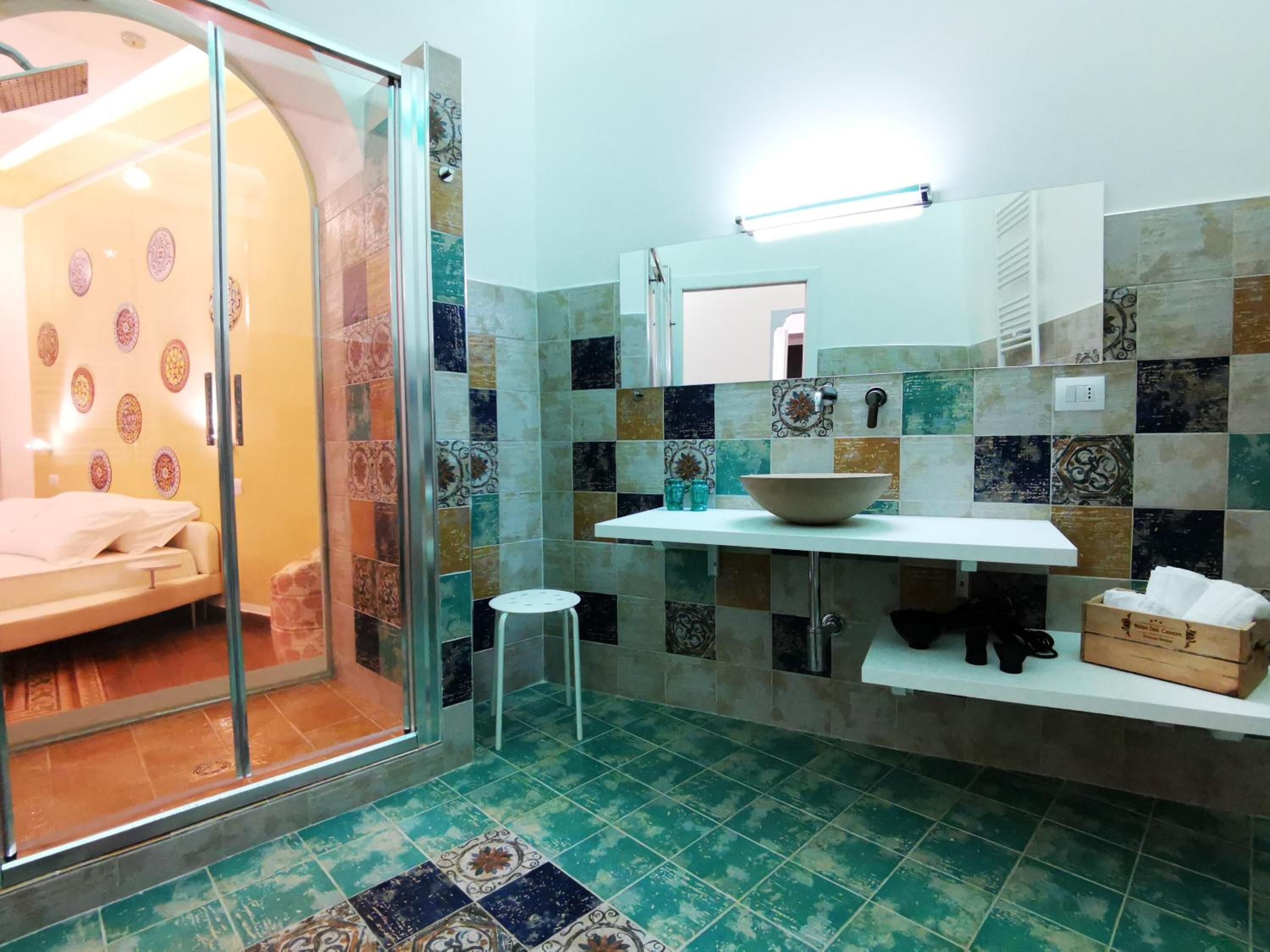 A bathroom with a shower, a sink with a bowl, and a mirror.