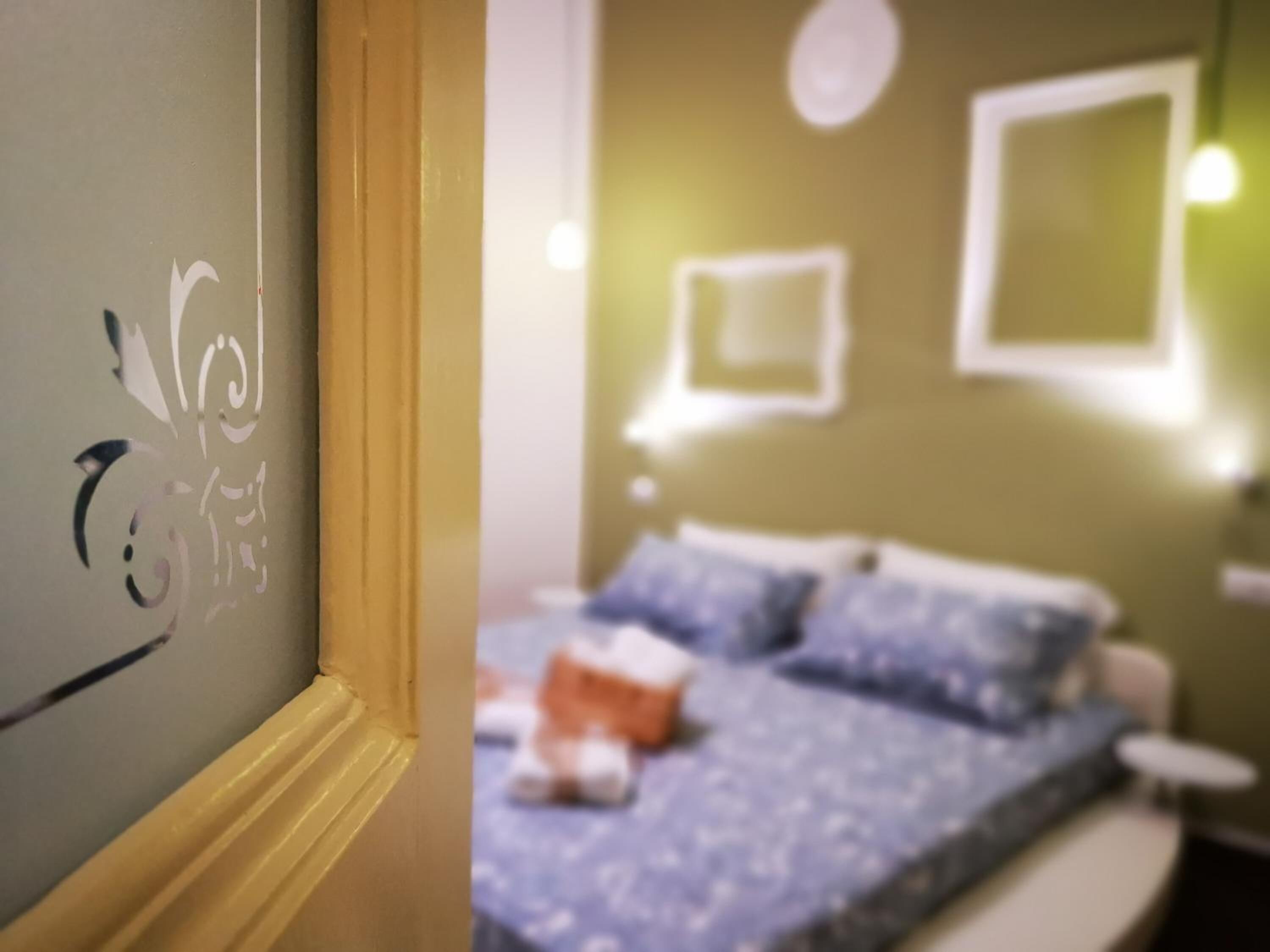 Una habitación con una cama, una mesita de noche y una lámpara de pared.