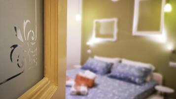 Una habitación con una cama, una mesita de noche y una lámpara de pared.