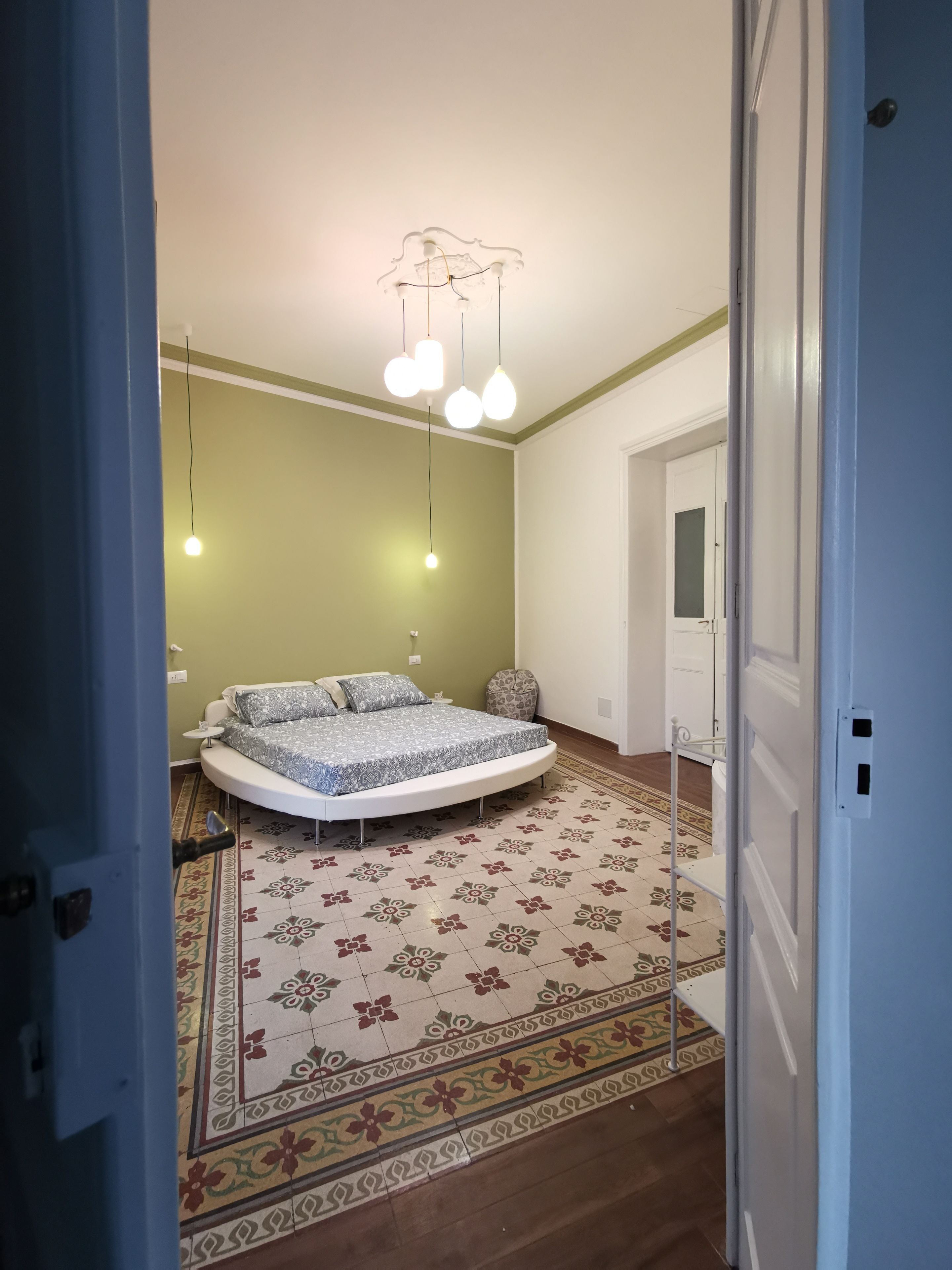 Une chambre à coucher avec un lit rond, un tapis à motifs et des lampes suspendues.