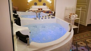 Un espace spa comprenant un grand jacuzzi, un porte-serviettes et un mur décoratif.