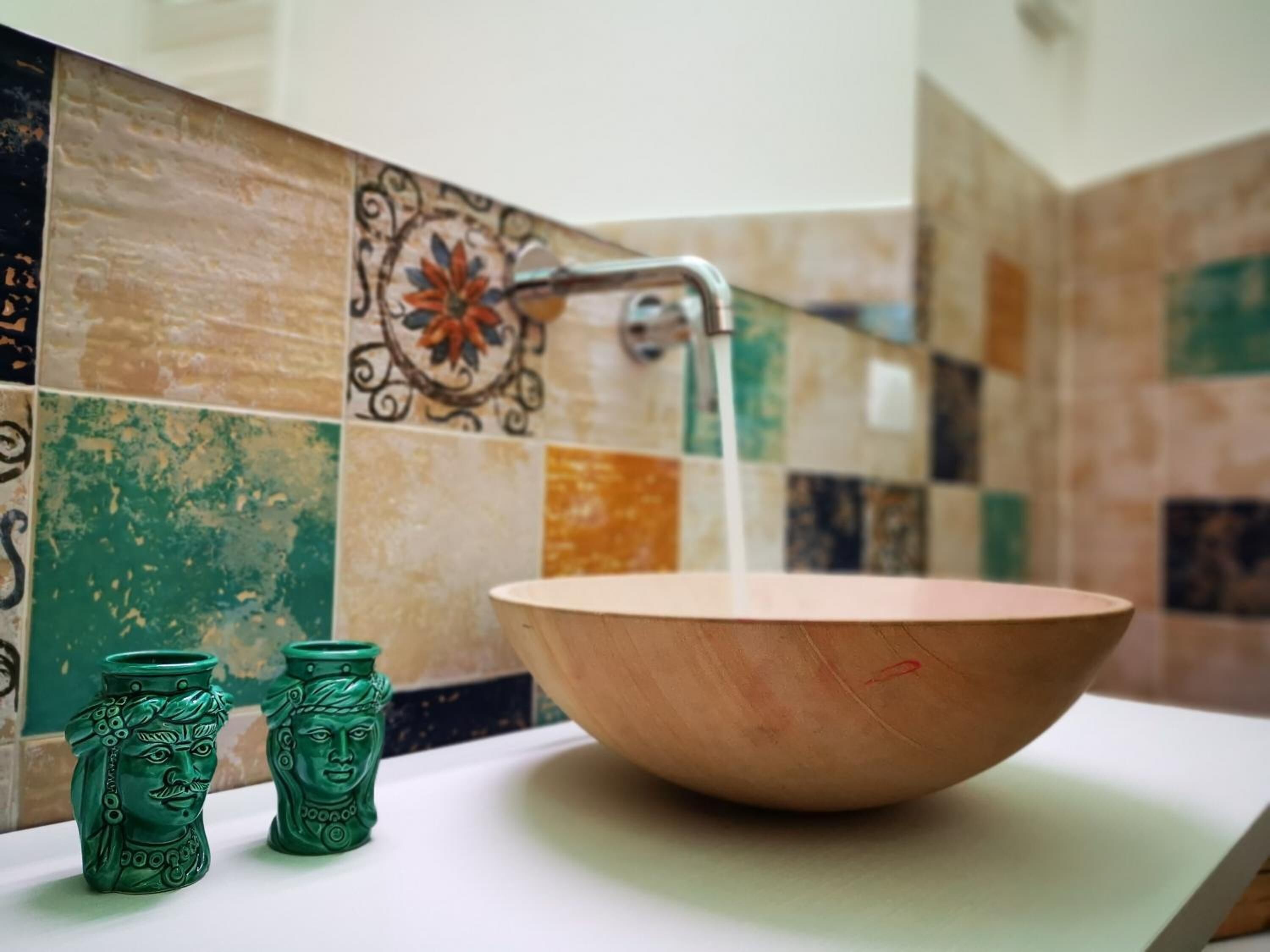 A bathroom with a wooden sink and a decorative tile backsplash.