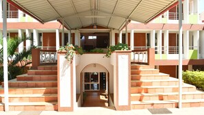 A building with a covered entrance, multiple staircases, and a central archway. - River Palace (Wai)